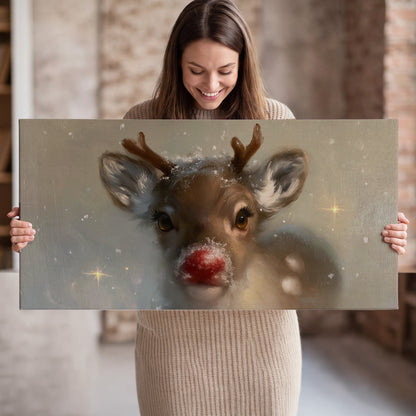 A young reindeer with a bright red nose surrounded by soft snowflakes and tiny painted stars single canvas wall art held in hands