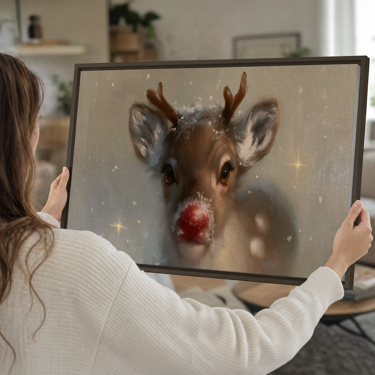 A young reindeer with a bright red nose surrounded by soft snowflakes and tiny painted stars single framed canvas wall art held in hands