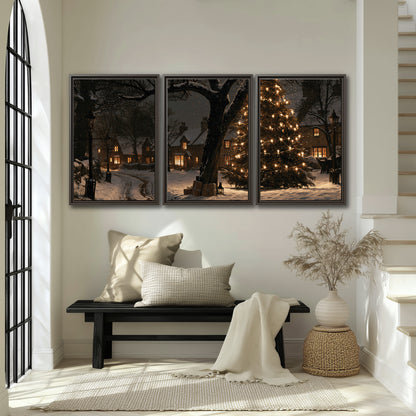 A tall illuminated Christmas tree beneath dark branches beside warmly lit snowy cottages 3 piece framed canvas wall art displayed in a entryway