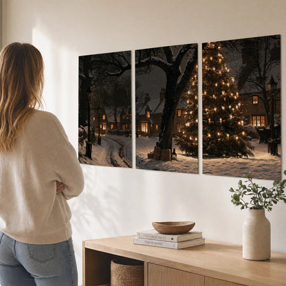 A tall illuminated Christmas tree beneath dark branches beside warmly lit snowy cottages set of 3 poster prints three panel arrangement on a wall