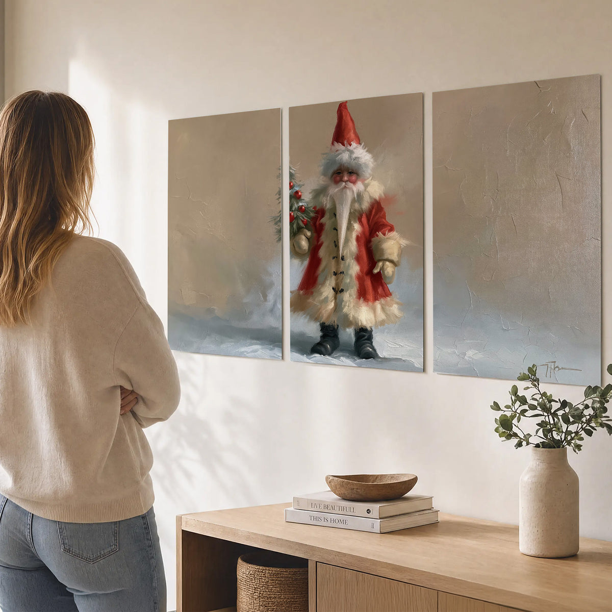 A small storybook Santa in a red coat holding a miniature Christmas tree against a soft neutral background set of 3 poster prints three panel arrangement on a wall