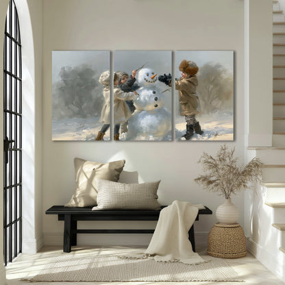 Two children putting the finishing touches on a snowman in a soft snowy landscape 3 piece canvas wall art displayed in a entryway