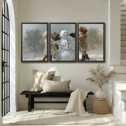 Two children putting the finishing touches on a snowman in a soft snowy landscape 3 piece framed canvas wall art displayed in a entryway