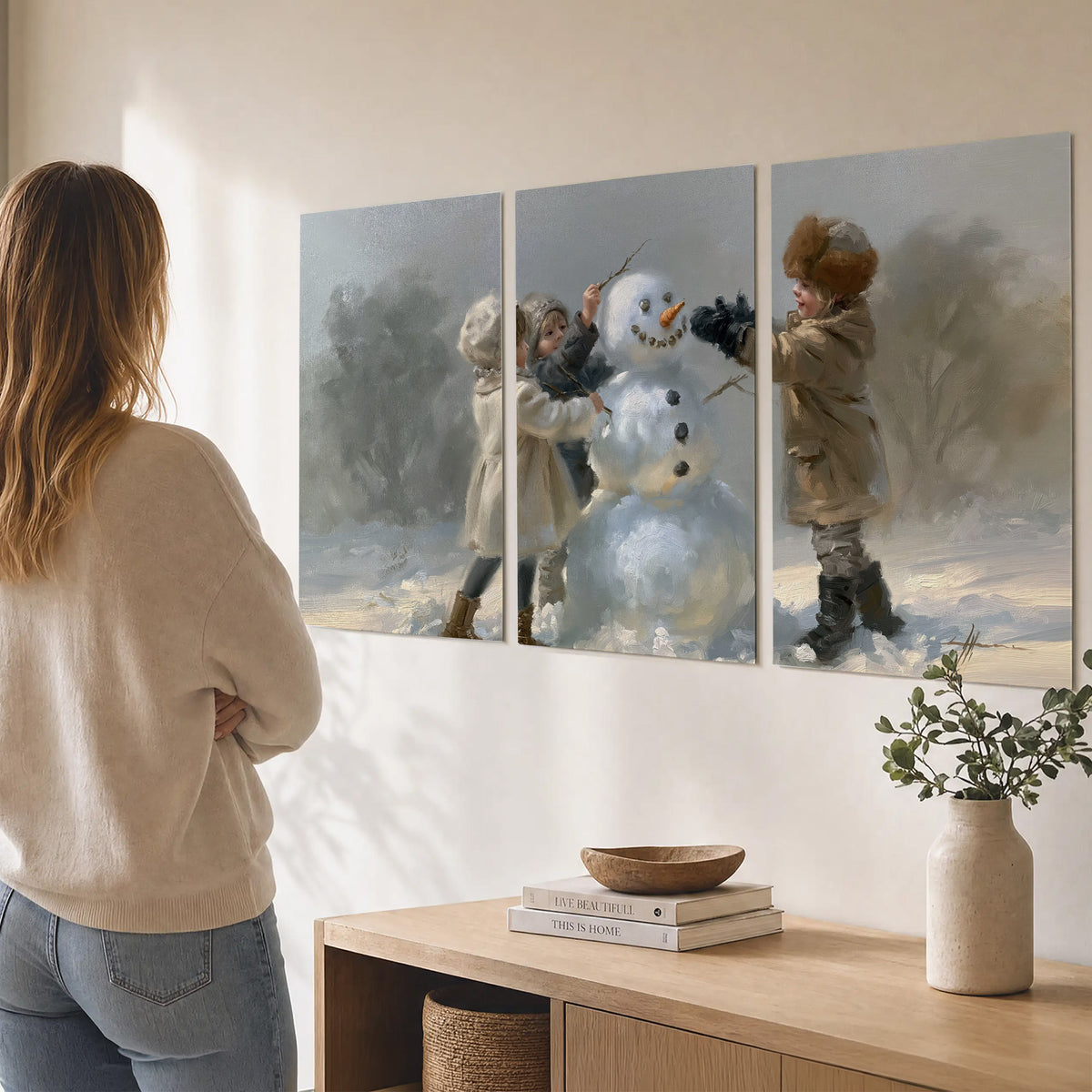 Two children putting the finishing touches on a snowman in a soft snowy landscape set of 3 poster prints three panel arrangement on a wall