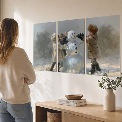 Two children putting the finishing touches on a snowman in a soft snowy landscape set of 3 poster prints three panel arrangement on a wall