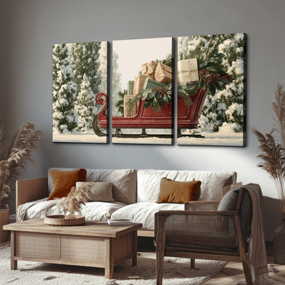 A red sleigh filled with wrapped gifts and evergreen branches among snowy fir trees 3 piece canvas wall art displayed in a rustic living room