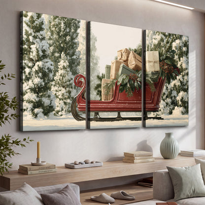 A red sleigh filled with wrapped gifts and evergreen branches among snowy fir trees 3 piece canvas wall art displayed in a console