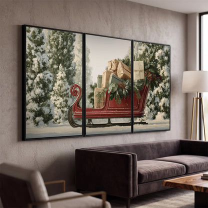 A red sleigh filled with wrapped gifts and evergreen branches among snowy fir trees 3 piece framed canvas wall art displayed in a modern living room