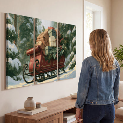 A red sleigh stacked with warm neutral gifts beneath snow-covered evergreen branches 3 piece canvas wall art three panel arrangement on a wall