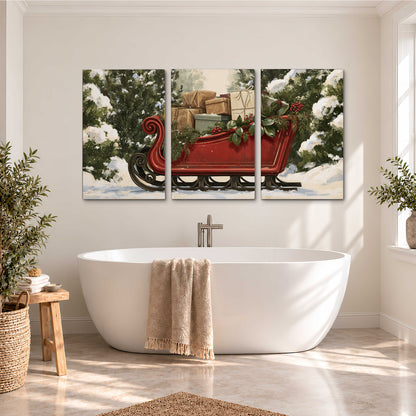 A decorative red holiday sleigh carrying wrapped presents and greenery through a snowy woodland 3 piece canvas wall art styled in an interior