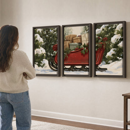 A decorative red holiday sleigh carrying wrapped presents and greenery through a snowy woodland 3 piece framed canvas wall art three panel arrangement on a wall