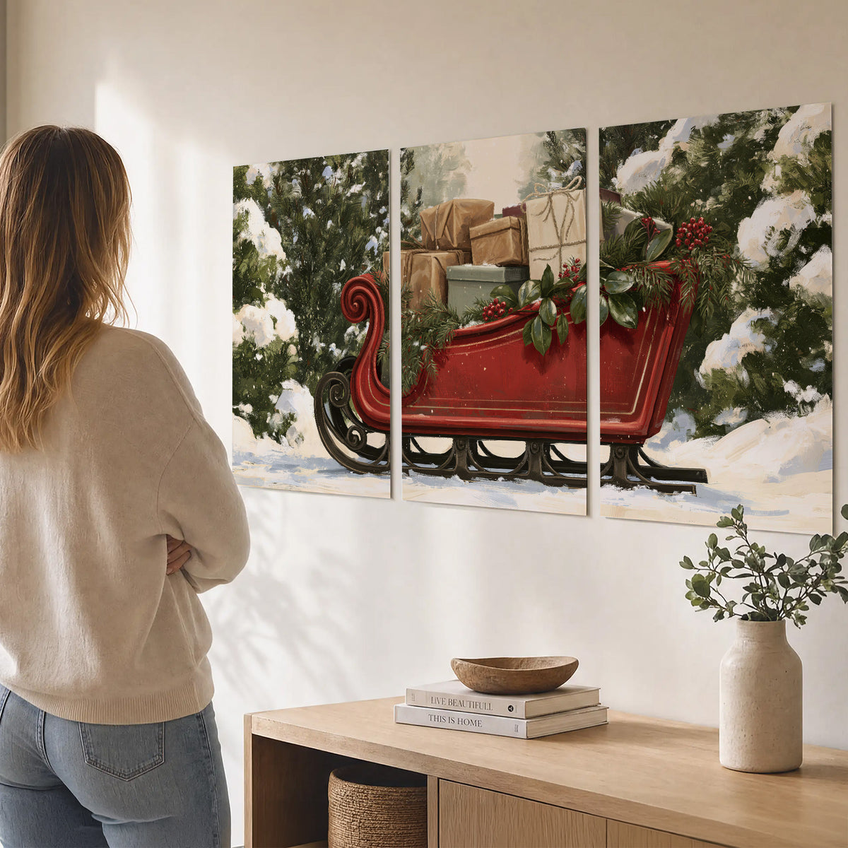 A decorative red holiday sleigh carrying wrapped presents and greenery through a snowy woodland set of 3 poster prints three panel arrangement on a wall