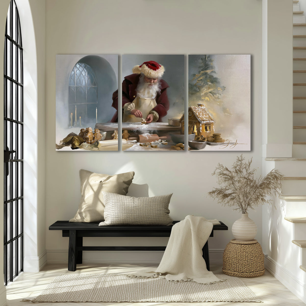 Santa working with dough beside a gingerbread house in a softly lit Christmas kitchen 3 piece canvas wall art displayed in a entryway