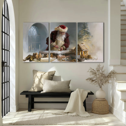 Santa working with dough beside a gingerbread house in a softly lit Christmas kitchen 3 piece canvas wall art displayed in a entryway