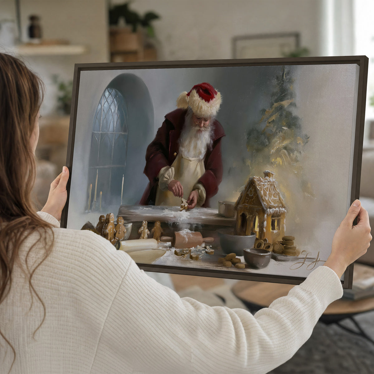 Santa working with dough beside a gingerbread house in a softly lit Christmas kitchen single framed canvas wall art held in hands