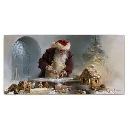 Santa working with dough beside a gingerbread house in a softly lit Christmas kitchen single canvas wall art viewed straight on