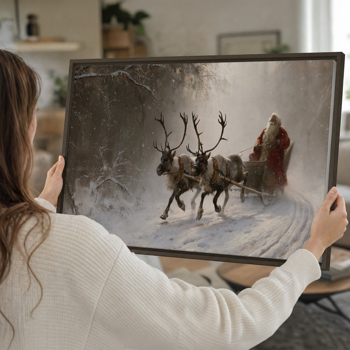 Santa riding a reindeer-drawn sleigh along a winding snowy woodland path single framed canvas wall art held in hands