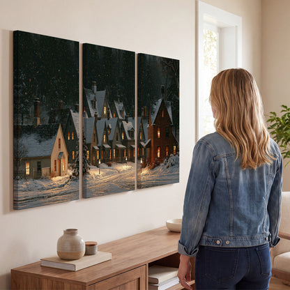 Snow-covered village cottages with glowing windows beneath a dark evergreen forest 3 piece canvas wall art three panel arrangement on a wall