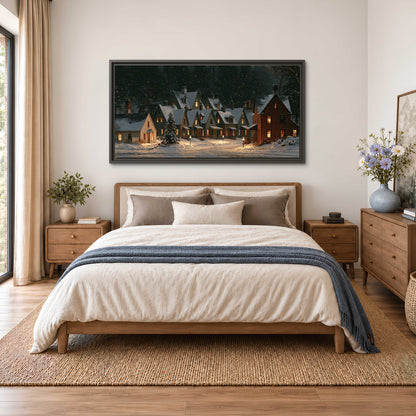 Snow-covered village cottages with glowing windows beneath a dark evergreen forest single framed canvas wall art styled in an interior