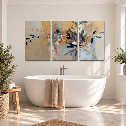 Loose dark blue leaves and pale blossoms on a warm beige painterly background 3 piece canvas wall art styled in an interior