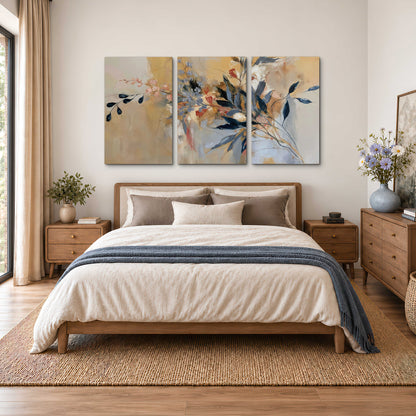 Loose dark blue leaves and pale blossoms on a warm beige painterly background 3 piece canvas wall art styled in an interior