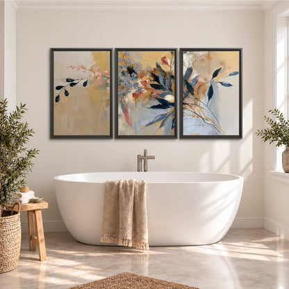 Loose dark blue leaves and pale blossoms on a warm beige painterly background 3 piece framed canvas wall art styled in an interior