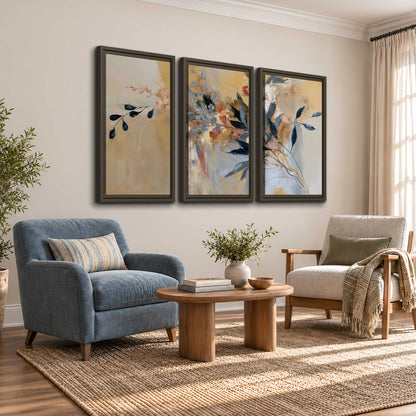 Loose dark blue leaves and pale blossoms on a warm beige painterly background 3 piece framed canvas wall art styled in an interior