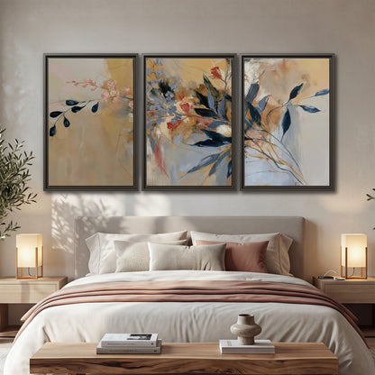 Loose dark blue leaves and pale blossoms on a warm beige painterly background 3 piece framed canvas wall art displayed in a bedroom