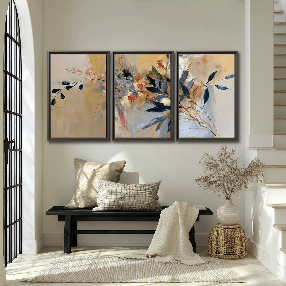 Loose dark blue leaves and pale blossoms on a warm beige painterly background 3 piece framed canvas wall art displayed in a entryway