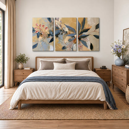 Layered navy leaves and muted pink blossoms against a golden cream background 3 piece canvas wall art styled in an interior