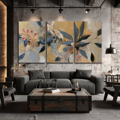 Layered navy leaves and muted pink blossoms against a golden cream background 3 piece canvas wall art displayed in a industrial room