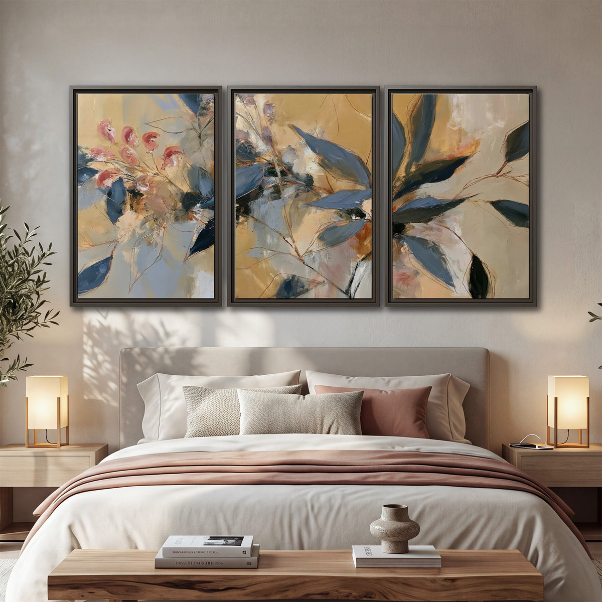 Layered navy leaves and muted pink blossoms against a golden cream background 3 piece framed canvas wall art displayed in a bedroom
