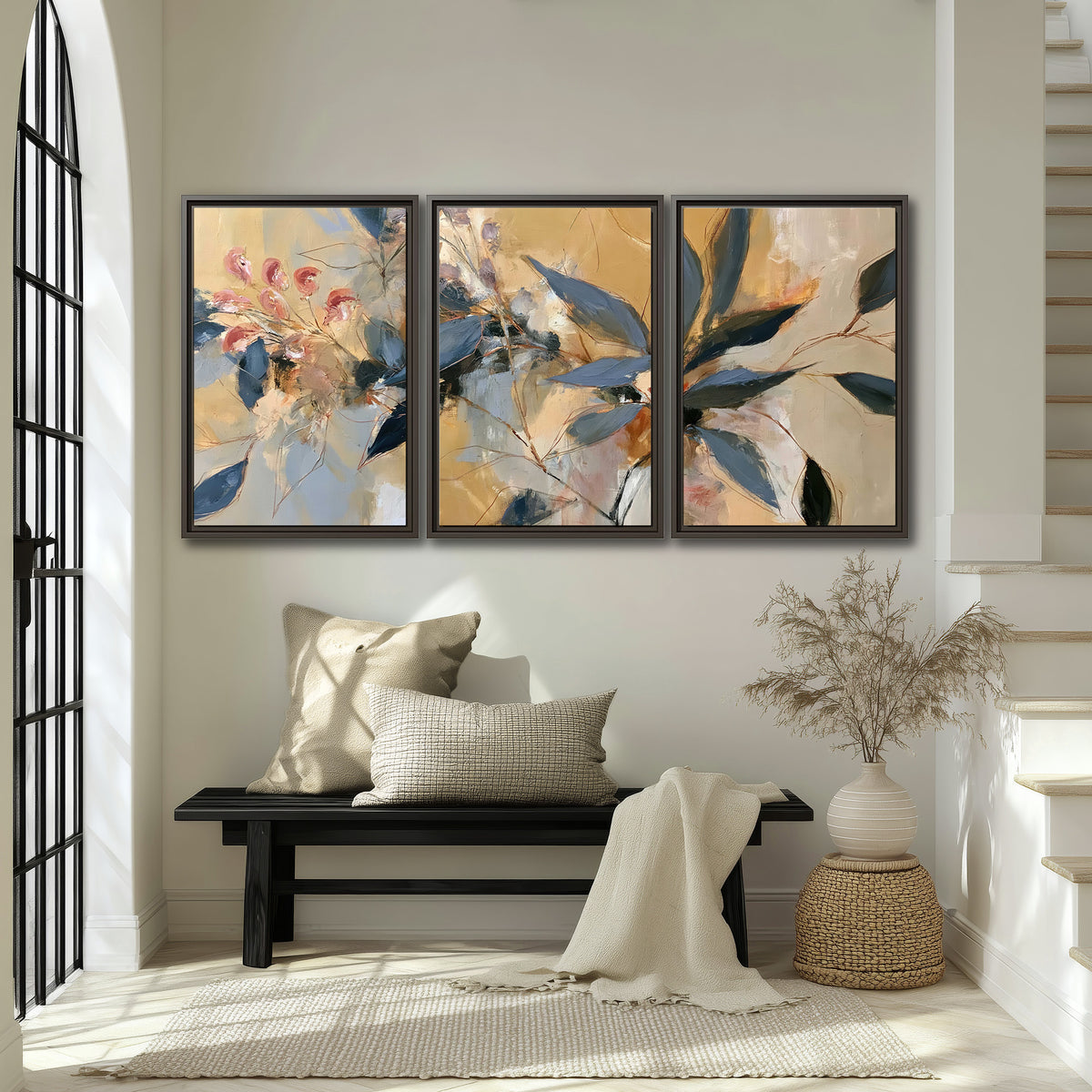 Layered navy leaves and muted pink blossoms against a golden cream background 3 piece framed canvas wall art displayed in a entryway