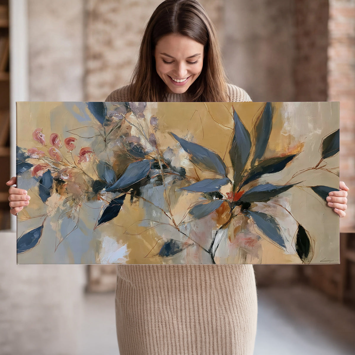Layered navy leaves and muted pink blossoms against a golden cream background single canvas wall art held in hands