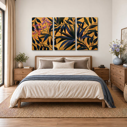 Dark pointed bamboo leaves across an ochre background with small pink floral accents 3 piece canvas wall art styled in an interior