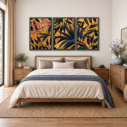 Dark pointed bamboo leaves across an ochre background with small pink floral accents 3 piece framed canvas wall art styled in an interior
