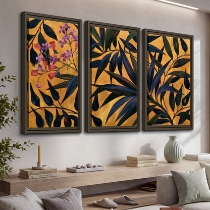 Dark pointed bamboo leaves across an ochre background with small pink floral accents 3 piece framed canvas wall art displayed in a console