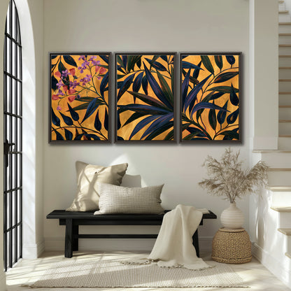 Dark pointed bamboo leaves across an ochre background with small pink floral accents 3 piece framed canvas wall art displayed in a entryway