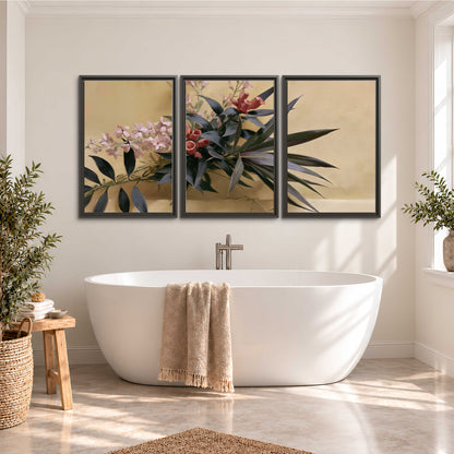 Long dark leaves and dusty pink flowers arranged against a soft beige background 3 piece framed canvas wall art styled in an interior