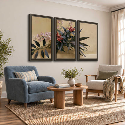 Long dark leaves and dusty pink flowers arranged against a soft beige background 3 piece framed canvas wall art styled in an interior