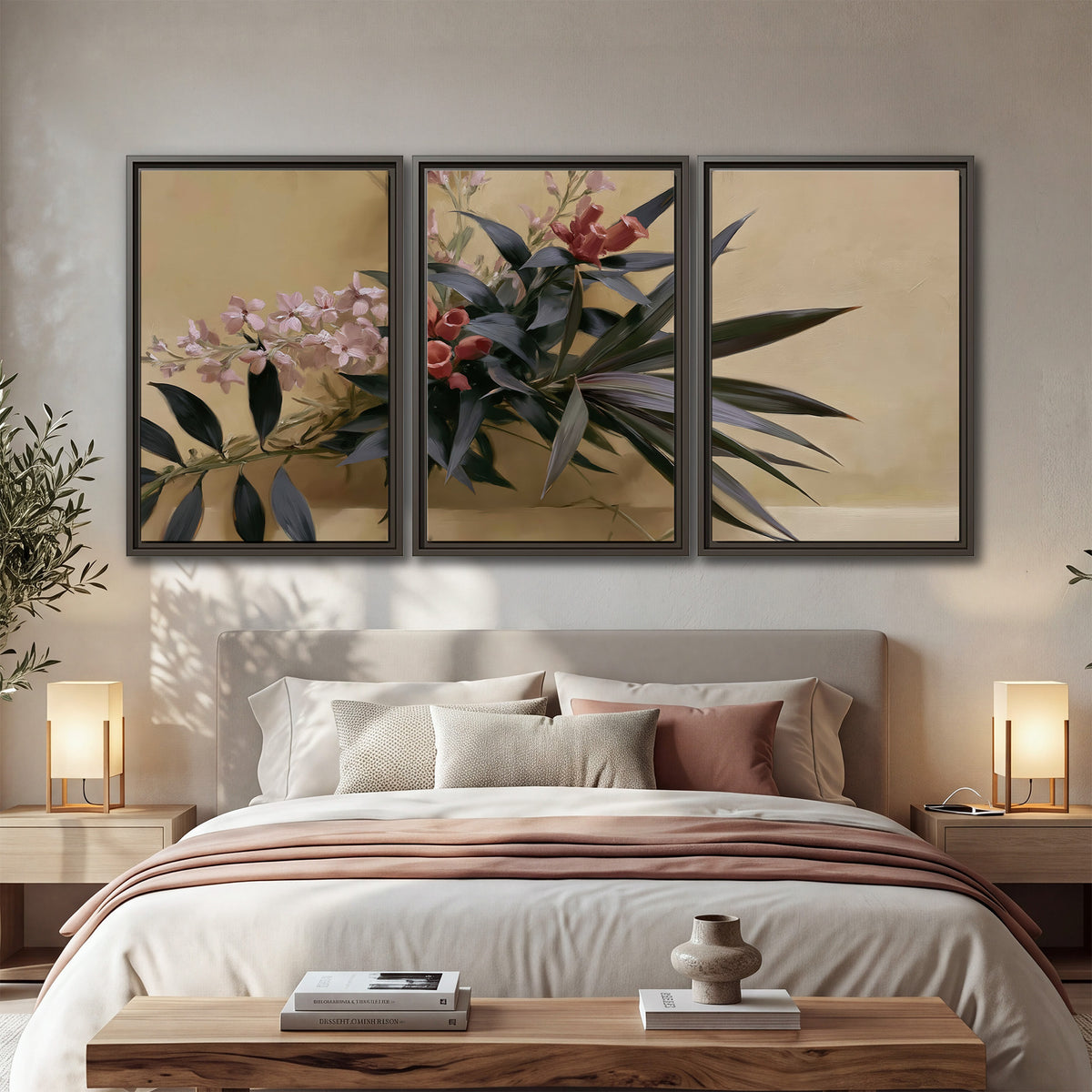 Long dark leaves and dusty pink flowers arranged against a soft beige background 3 piece framed canvas wall art displayed in a bedroom