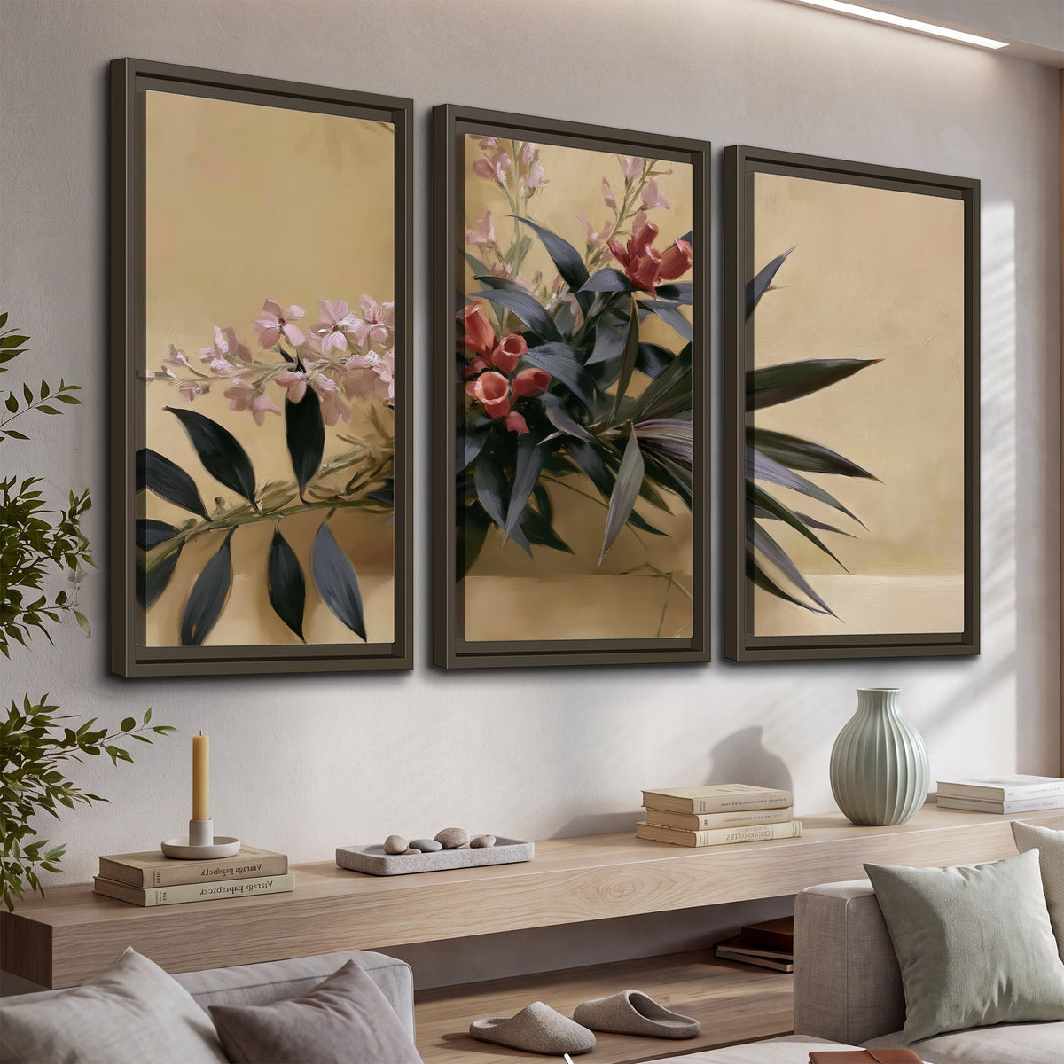 Long dark leaves and dusty pink flowers arranged against a soft beige background 3 piece framed canvas wall art displayed in a console