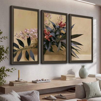 Long dark leaves and dusty pink flowers arranged against a soft beige background 3 piece framed canvas wall art displayed in a console