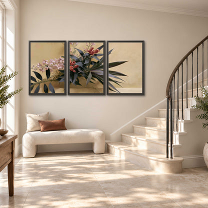 Long dark leaves and dusty pink flowers arranged against a soft beige background 3 piece framed canvas wall art styled in an interior