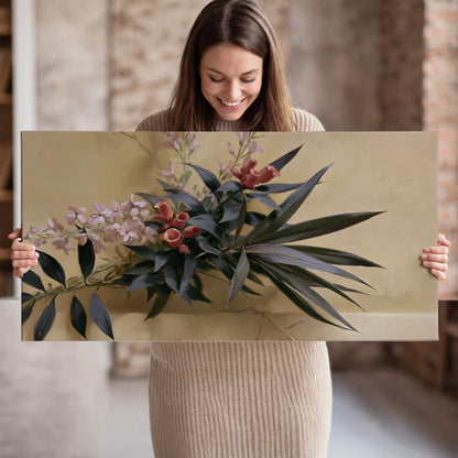 Long dark leaves and dusty pink flowers arranged against a soft beige background single canvas wall art held in hands