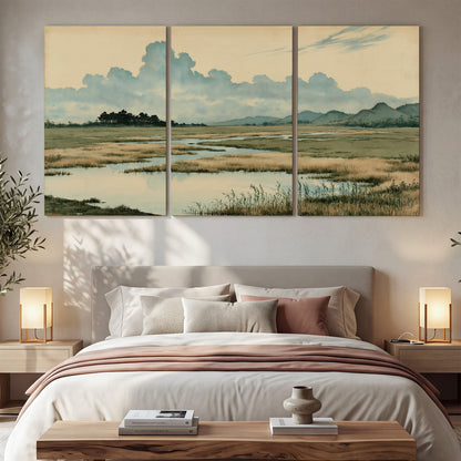 A calm marshland with reflective pools and distant blue-green hills under a clouded sky 3 piece canvas wall art displayed in a bedroom