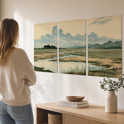 A calm marshland with reflective pools and distant blue-green hills under a clouded sky set of 3 poster prints three panel arrangement on a wall