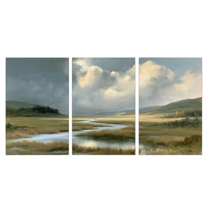 A winding stream through an open meadow beneath large sunlit clouds 3 piece canvas wall art viewed straight on