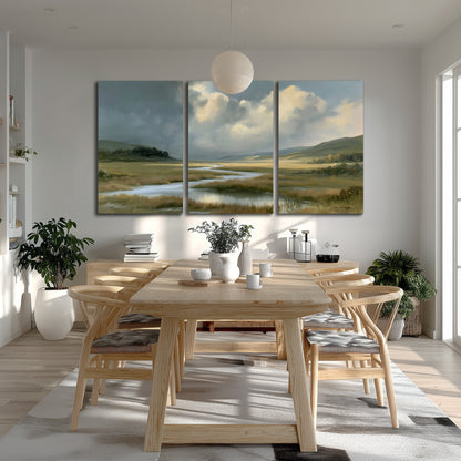 A winding stream through an open meadow beneath large sunlit clouds 3 piece canvas wall art room and product view