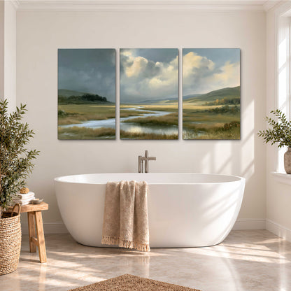 A winding stream through an open meadow beneath large sunlit clouds 3 piece canvas wall art styled in an interior